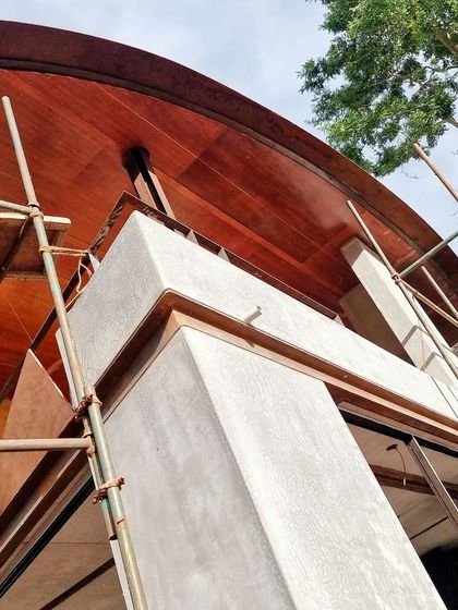 (Duplicate of 88) The upward view of the curved roof under construction highlights the complex geometry and the interplay between the structural steel and the warm wood cladding.