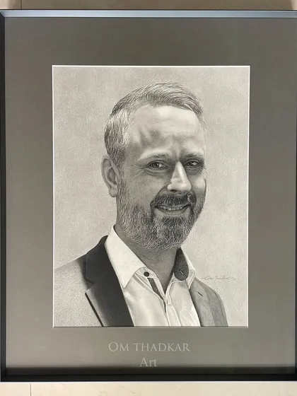 This is another example of a commissioned portrait, professionally framed. My process involves working closely with clients to understand the person I am drawing, which helps me to bring out their warm and approachable nature in the final piece.