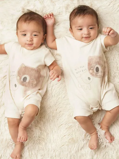 The twin boys are holding hands, a perfect illustration of their lifelong bond. Capturing these details is what twin photography is all about.