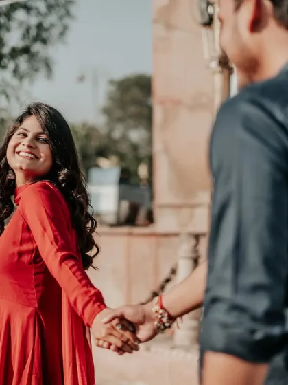 The classic "follow me" pose, full of joy and anticipation. The bride's bright smile and the candid nature of the shot make it a favorite.