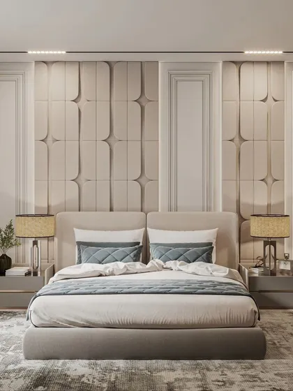 We create tranquil master bedrooms that serve as personal retreats. This design features a custom upholstered headboard with 3D paneling, elegant side tables, and layered lighting to create a calm and sophisticated atmosphere for restful nights.