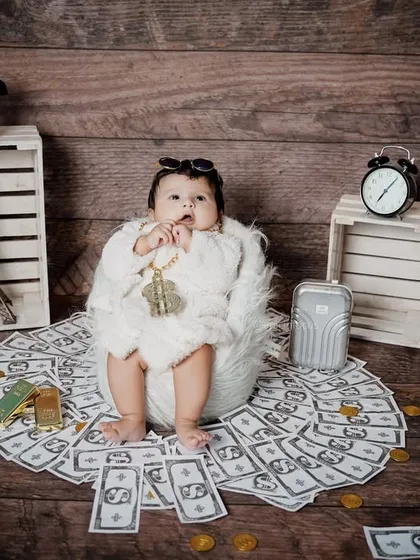 This "Boss Baby" is ready for business. Surrounded by prop money and wearing a fluffy robe, this humorous theme captures a fun and confident personality.