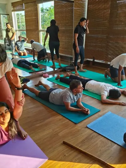 Assisting a student in a deep backbend. With the right support, students can safely explore more advanced postures and discover new levels of flexibility.