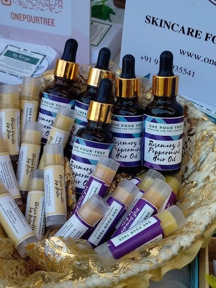 A beautiful display of my Rosemary & Peppermint Hair Oil alongside various lip balms. This showcases some of the key items in my handmade skincare and hair care line.