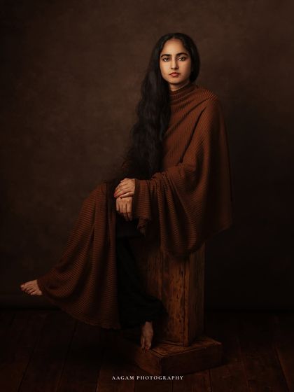 "I Dream my Painting & Paint my Dream." This portrait, with the subject seated on a rustic wooden block, has a raw, artistic, and grounded feel.