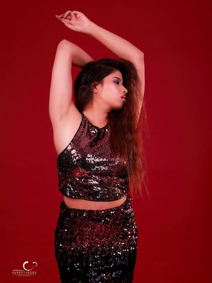 An elegant and artistic pose with arms raised. The composition is graceful and highlights the flow of her hair.