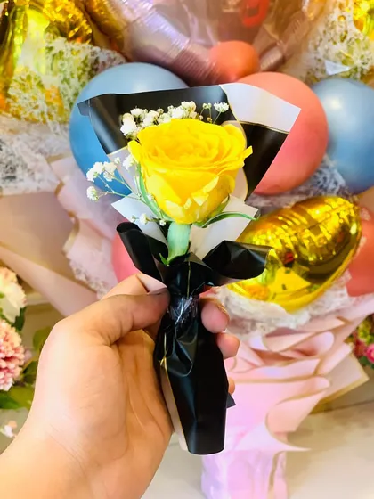 A single yellow rose mini-bouquet, wrapped in black paper with a black ribbon. This is a modern and stylish way to express friendship and joy.