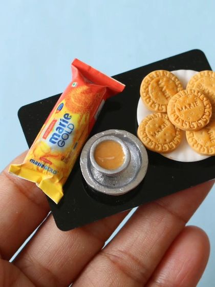A close-up of a Marie Gold biscuit platter with a tiny cup of chai, a classic combination.