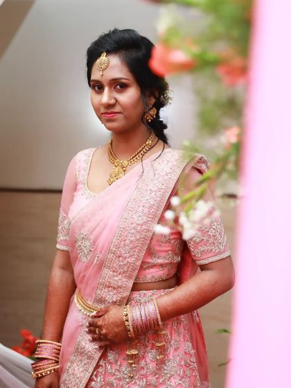 For this engagement, we chose a beautiful pink lehenga saree. The makeup look is soft and pretty, with a matching pink lip, defined eyes, and a traditional maang tikka.
