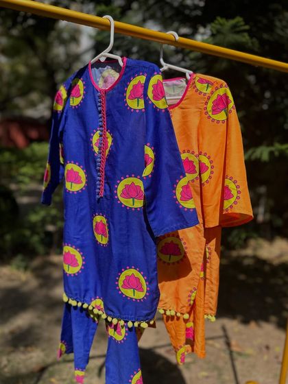 Beat the heat in style with my summer-ready sets. This image shows my vibrant lotus-print kurtas in royal blue and bright orange, perfect for adding a pop of color to your child's wardrobe.