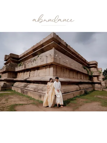 A wide shot of a couple by a temple, with a text overlay adding an artistic touch to the grand scene.