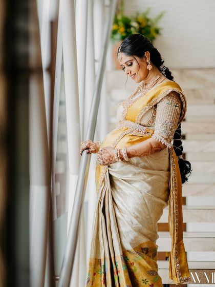 A portrait of me at my baby shower, glowing in a beautiful yellow and white Kanchipuram silk saree with a heavily embroidered blouse.