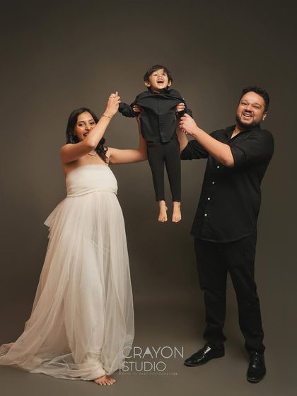 Pure joy and excitement for the new arrival. The parents playfully lift their son, his laughter filling the studio. This image captures the happy energy of a growing family.