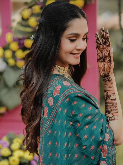 A beautiful bride looking over her shoulder, giving a glimpse of her elegant mehandi.