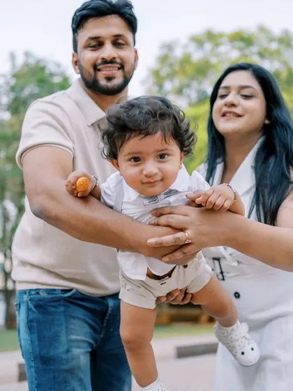 A first birthday shoot isn't complete without capturing the whole family's joy. This playful outdoor moment shows the pure happiness of celebrating one whole year together.