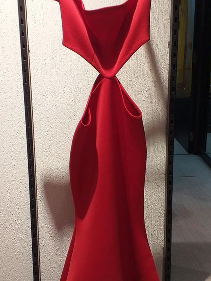 A daring red gown with cutouts at the waist and a unique neckline. This is a high-fashion piece for a confident woman who wants to make a memorable entrance.