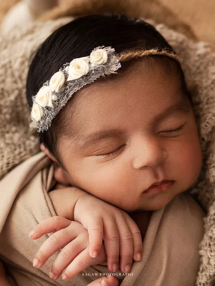 A close-up on this little one's face, showing the delicate details of the burlap and lace headband.