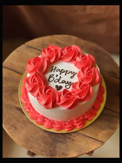A classic birthday cake with a simple message, beautifully framed with hand-piped red buttercream roses.