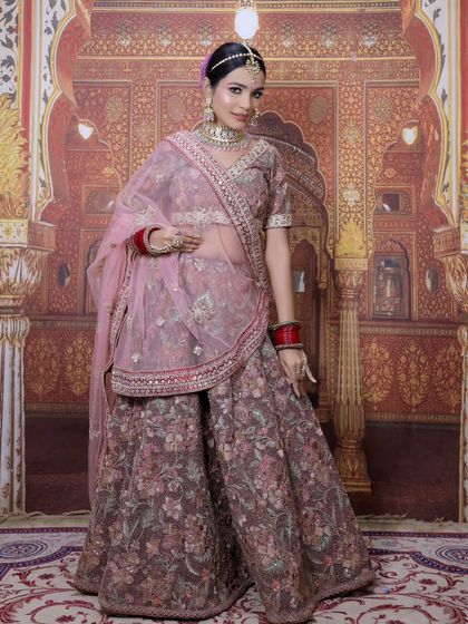 A full-length shot of the elegant mauve-pink floral lehenga. This outfit is light, comfortable, and perfect for dancing the night away at a sangeet.