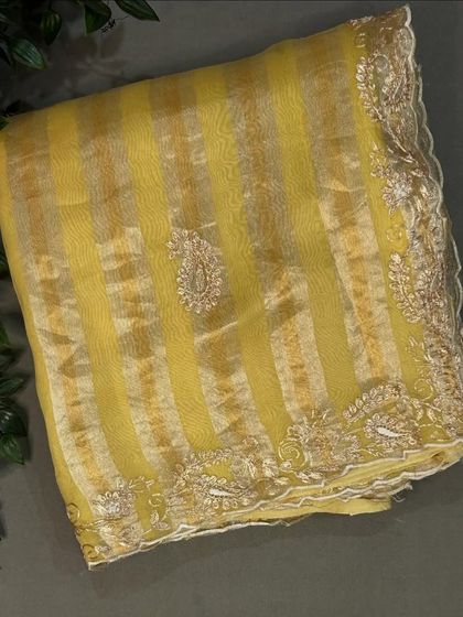Another view of the yellow tissue stripes organza saree, showing the shimmer of the fabric.