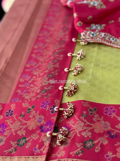 A unique border detail using clustered bead tassels, adding texture and a traditional touch to this pink floral brocade saree.