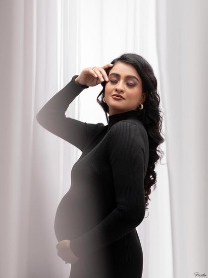 A soft, artistic portrait using a lens flare effect. The focus is on her serene expression and the beautiful shape of her silhouette.