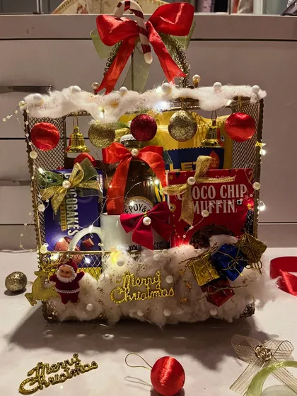 I love bringing that cozy Christmas feeling to life. This festive hamper is a winter wonderland in a basket, complete with fairy lights, faux snow, and delicious treats to make your Secret Santa gift the most memorable one.