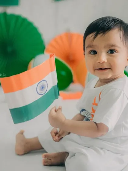 This little patriot is proudly holding the flag, a perfect memory from his first Independence Day.