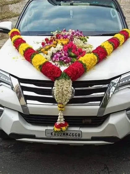 Your wedding car will look perfect for the occasion. I provide custom car decoration services using fresh flower garlands, like this traditional red and yellow marigold arrangement on a Toyota Fortuner for a grand send-off.
