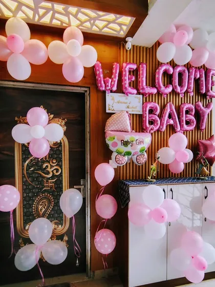 A simple and sweet "Welcome Baby" girl decoration for a doorway, using pink and white balloons and a baby carriage foil balloon.