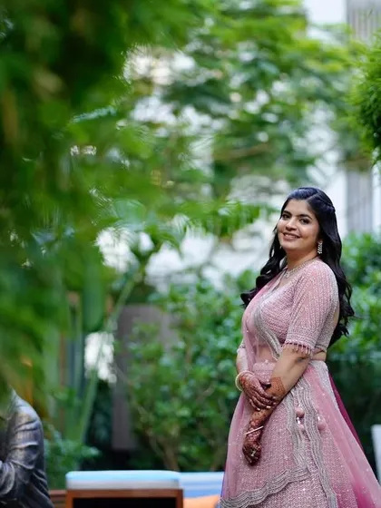 A fresh and minimal engagement look. The bride is surrounded by greenery, and her makeup is kept natural and radiant to match the outdoor setting.