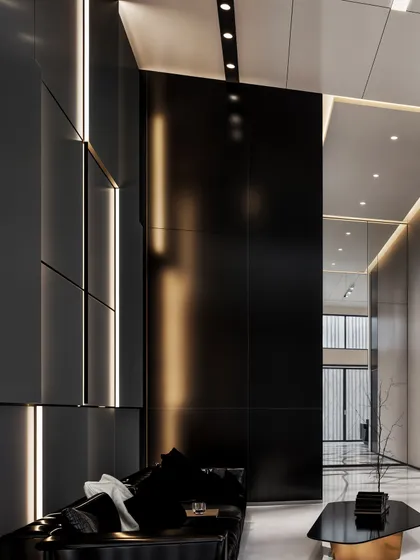 A moody seating area in the lobby, with black leather sofas set against tall, black wall panels with integrated lighting.