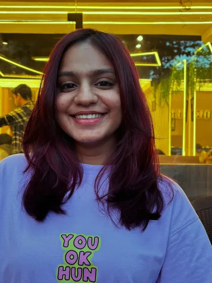 A smiling client with her new Malbec Global Hair Color. The deep, wine-inspired tone is both bold and chic.