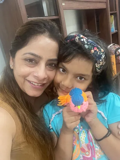 All smiles after our craft workshop. This young artist is happy to show the colorful yarn bird she made all by herself.