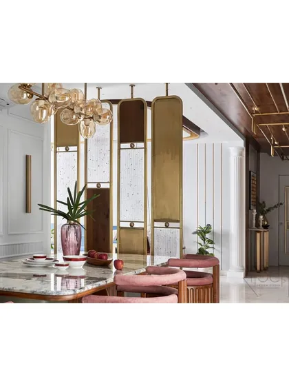 A closer look at the dining area, featuring a custom table and chairs that blend wood, brass, and soft pink upholstery. The entire space is designed with intricate details to feel cohesive and luxurious.