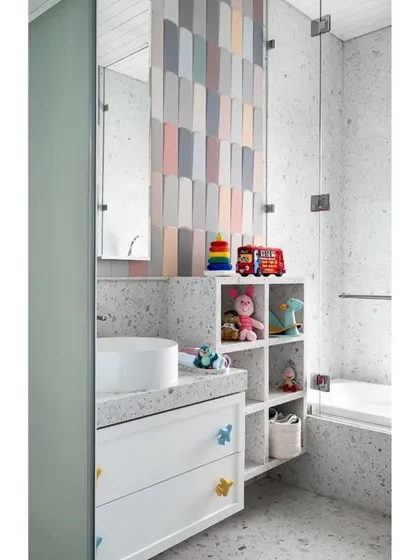 Remy's royal bath is fun and practical, with cupcake-colored tiles, a tub that doubles as a mini-pool, and open niches for all his favorite toys.