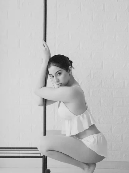 Another frame from the minimalist series, this time a more direct and composed squatting pose. The simplicity of the scene draws all attention to the model's form.