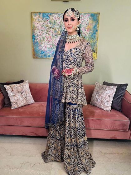 A stunning royal blue sharara set for a unique wedding day choice. The makeup is kept elegant and defined, with a focus on sharp eyes to balance the grandeur of the outfit.