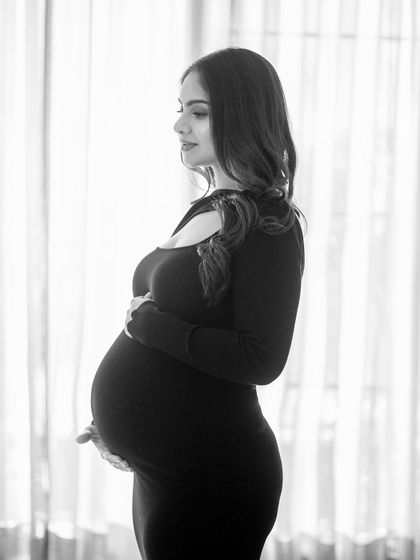 The timeless beauty of black and white. This classic profile shot in a black dress against a white background is simple, elegant, and focuses entirely on the silhouette of motherhood.