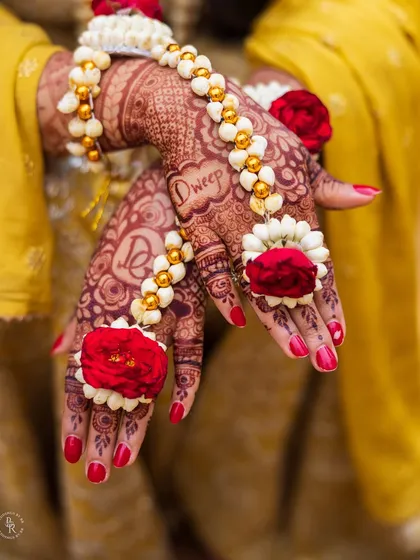 The beauty is in the details. Here, I've focused on the bride's hands, adorned with intricate mehendi and delicate floral jewelry, telling a story of tradition and love.