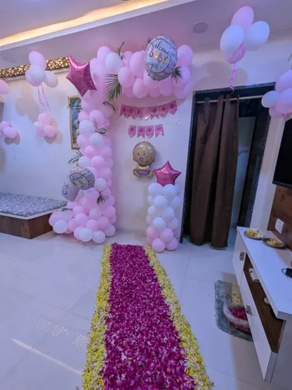 This image highlights the rich texture of the floral pathway, made with a thick layer of pink petals bordered by yellow ones. It creates a luxurious and traditional welcome for the new mother and baby.