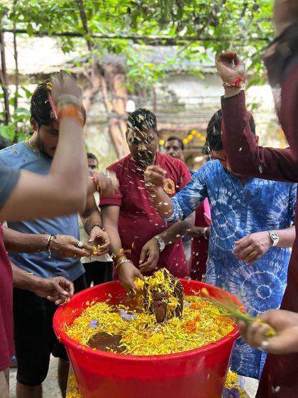 Showering the Ganesha idol with flower petals during the visarjan ceremony. This joyful and colorful moment marks the culmination of our festival.