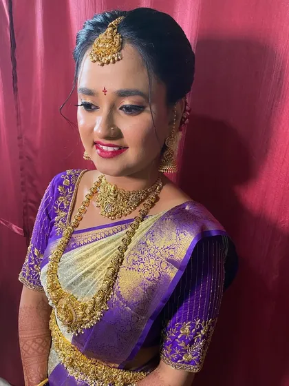 A beautiful bride with a classic updo, adorned with a traditional maang tikka. This is a timeless and elegant hairstyle for any wedding ceremony.