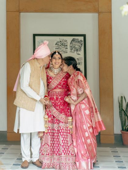A bride receiving kisses from her parents, a touching and emotional moment that I am honored to capture.