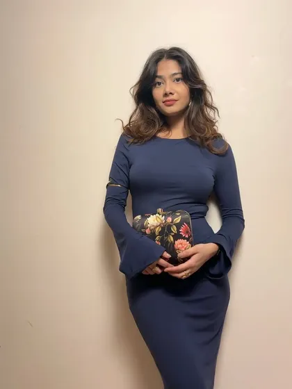 The clutch paired with a sleek navy dress. The floral print on the bag adds a lovely contrast to the solid color of the dress.