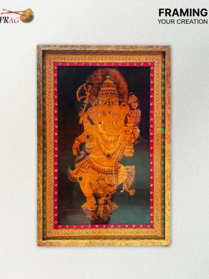A close-up of the framed Ganesha Tanjore painting, highlighting the craftsmanship of both the artwork and its protective frame.
