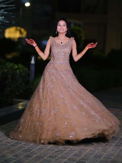 A happy and twirling bride-to-be at her engagement shoot. The full gown and elegant makeup create a fairytale moment.