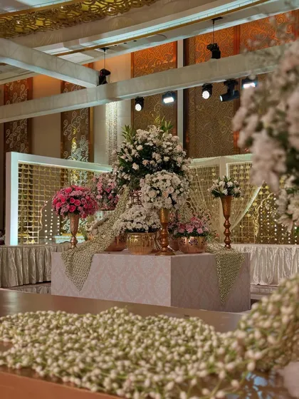 A wide shot of a floral installation, with a foreground of countless jasmine buds. This showcases the scale and sensory richness of our designs.