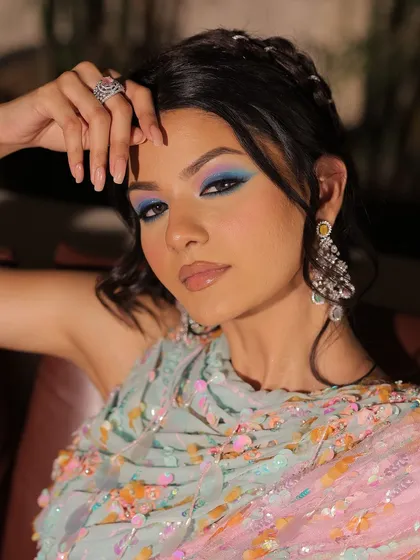 A final close-up of the beauty in a blink, focusing on the artistic and colorful eye makeup.