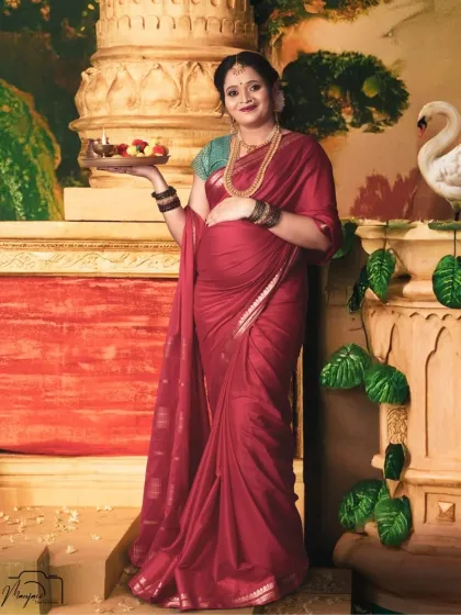 Holding a traditional thali (plate) of offerings, this mama-to-be looks radiant against another one of our artistic, temple-inspired painted backdrops.